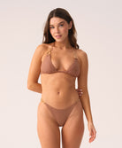 Woman wearing brown bikini set against white background. 