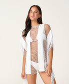 Woman wearing a white and brown patterned cover-up against a plain background