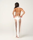 Woman wearing a white bikini with sheer side panels on a white background