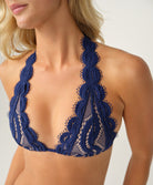 Navy blue lace bikini top worn by a model on a plain background
