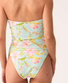 Woman wearing a floral-patterned swimsuit on a plain background