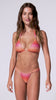 A woman wearing a red, pink, and orange ombre shimmery bikini with gold accents spinning in front of a white background.
