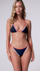 A woman wearing a navy triangle top bikini spinning in front of a white wall.