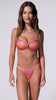 A woman wearing a red, pink, and orange shimmery ombre bikini with a gold accent in the front spinning in front of a white background.