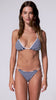 A woman wearing a blue and white striped bikini spinning against a white wall.