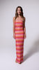 A woman wearing a red, pink, and orange shimmery ombre strapless maxi tube dress spinning in front of a white background.