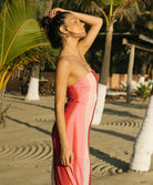 Scarlet Jane strapless dress with vibrant pink, red, and white chevron pattern and gold lurex shimmer, featuring a back slit.