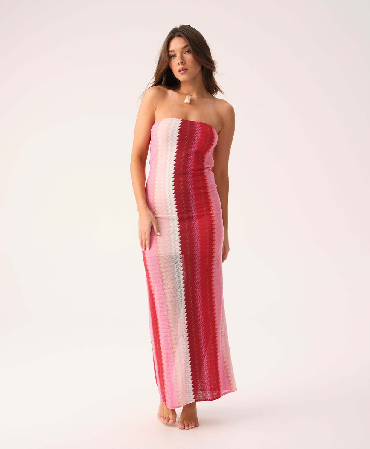 Scarlet Jane strapless dress with vibrant pink, red, and white chevron pattern and gold lurex shimmer, featuring a back slit.