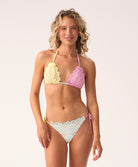 Woman wearing a colorful lace triangle bikini with a white background