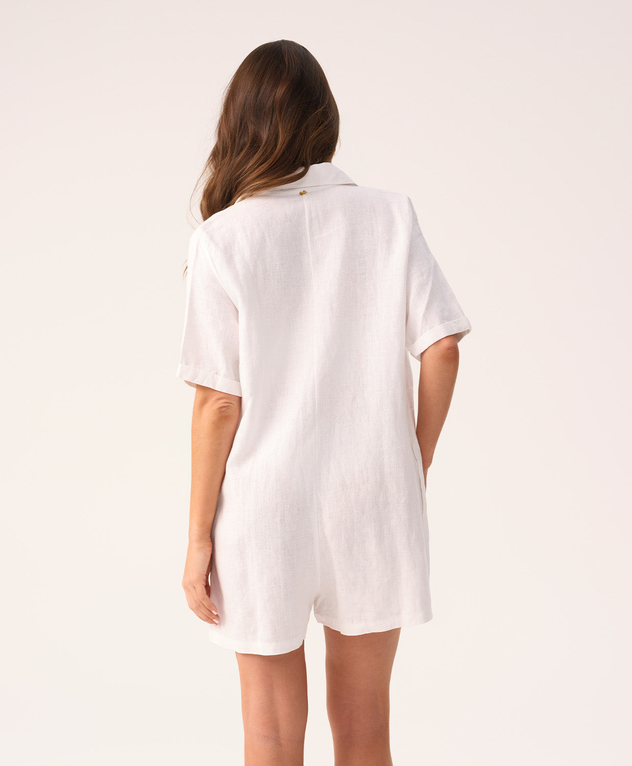 White linen romper with a collared neckline and front buttons