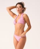 Woman wearing a pink lace bikini set on a white background