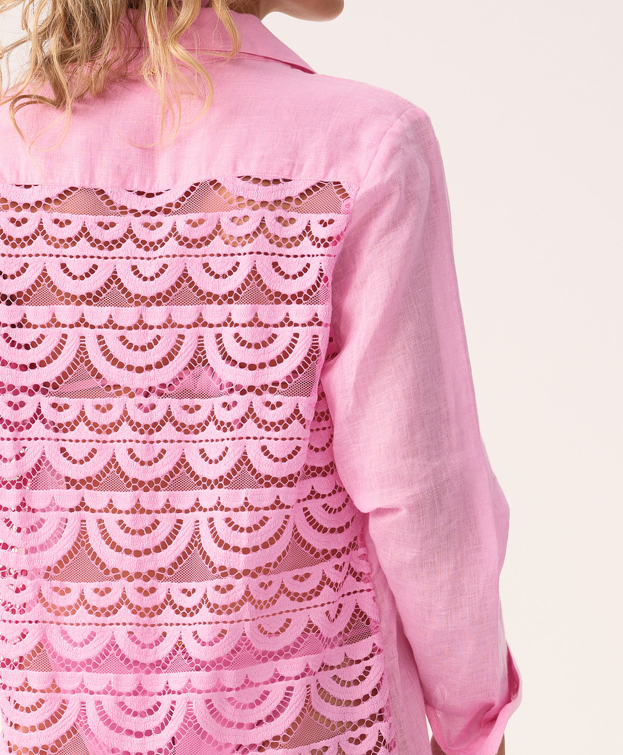 Pink lace-trimmed shirt with scalloped pattern on a white background