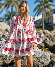 Blonde female wearing a white mini dress with hot ink floral embroideries